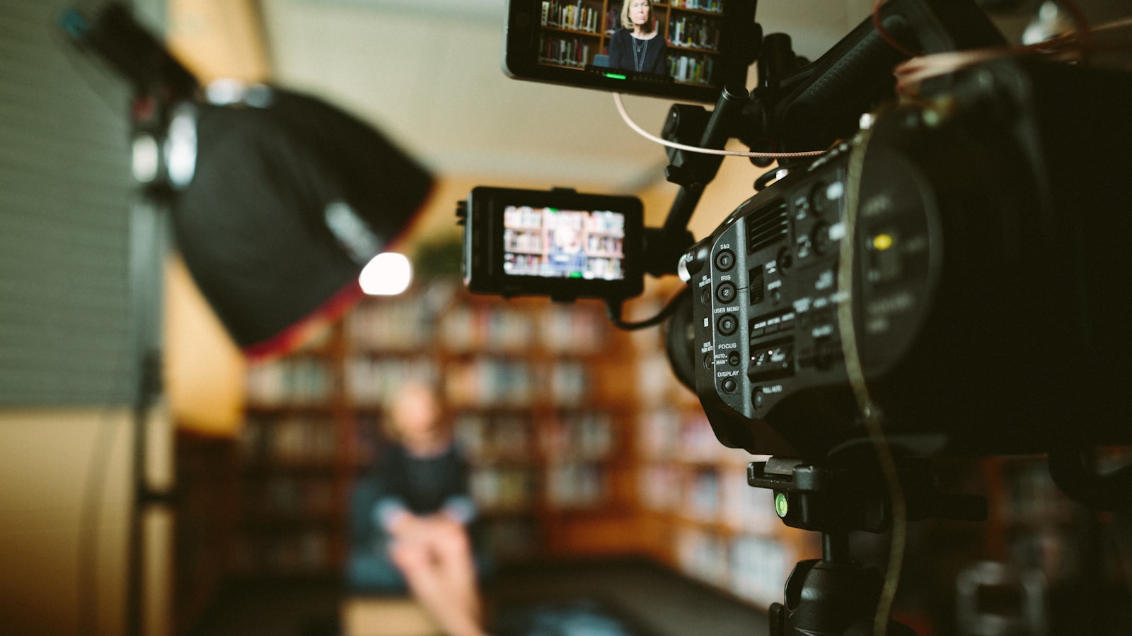 Personne assise devant une bibliothèque, ambiance de tournage documentaire